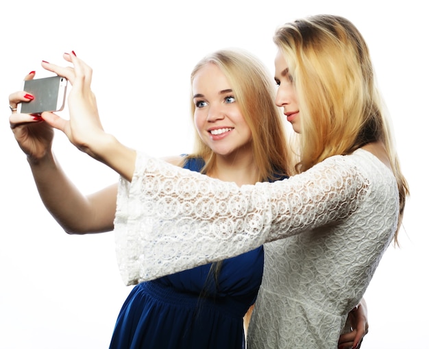 Mooie meiden die selfie nemen. Geïsoleerd op een witte achtergrond.