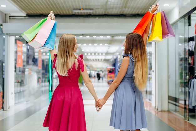 Mooie meisjes lopen rond het winkelcentrum na het winkelen