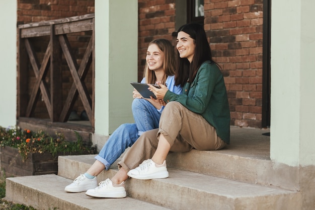 mooie meisjes zittend op trappen met tablet