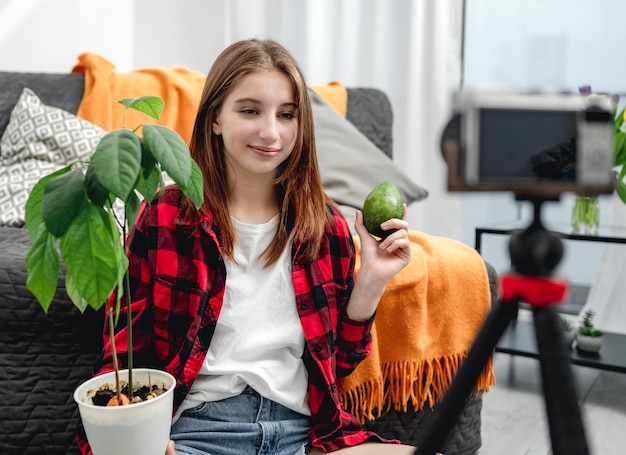 Mooie meisjestiener die leert avocado te kweken