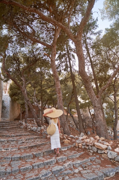 Mooie meisjestoerist die in de straten van hydra, griekenland loopt