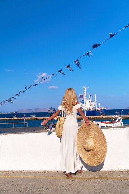 Mooie meisjestoerist die zich bij spetses marina seaport griekenland bevindt en naar de zee kijkt