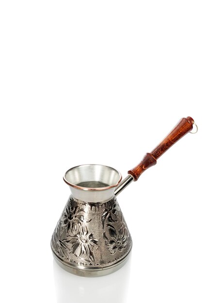 Mooie metalen cezve met een ornament en een houten handvat Traditionele bereiding van aromatische drank Geïsoleerd op witte achtergrond Vertical