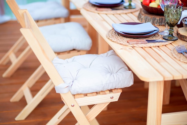 Mooie milieuvriendelijke houten meubels op het zomerterras van het restaurant Klapstoelen voor op de camping