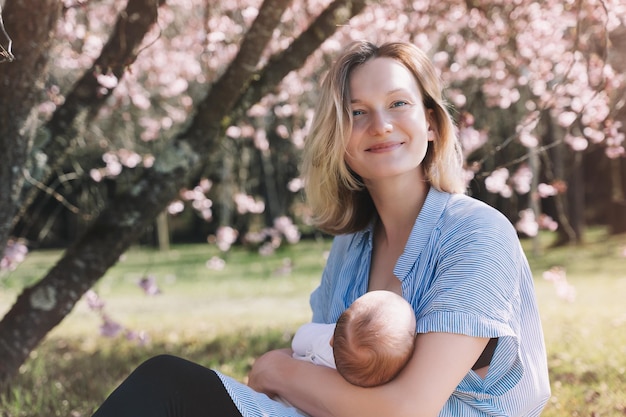 Mooie moeder die baby borstvoeding geeft Jonge vrouw die haar pasgeboren baby borstvoeding geeft