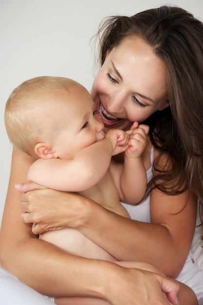 Mooie moeder die baby koesteren die samen lachen