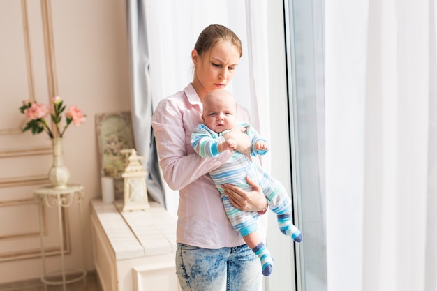 Mooie moeder die pasgeboren baby in armen houdt