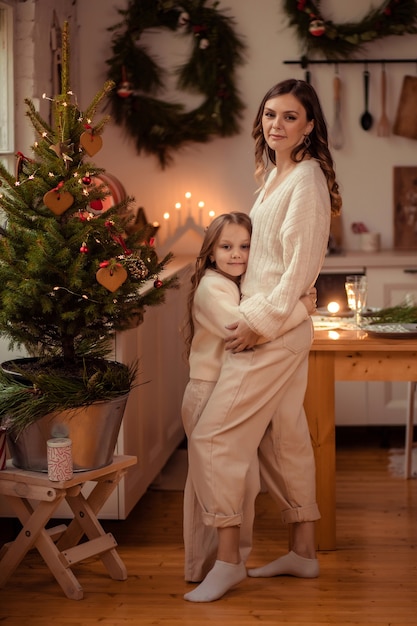 Mooie moeder en dochter in de buurt van de kerstboom