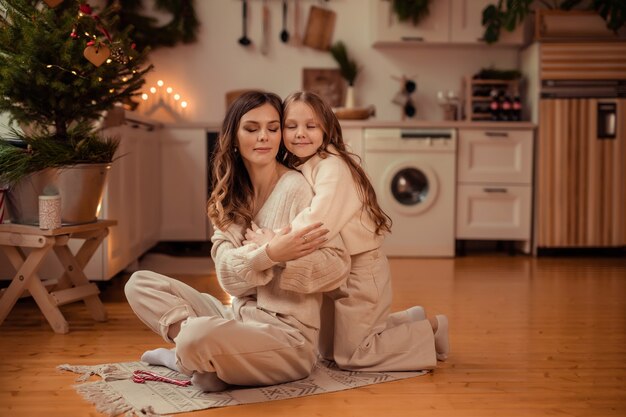 Mooie moeder en dochter in de buurt van de kerstboom