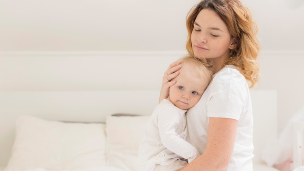 Mooie moeder haar babymeisje knuffelen