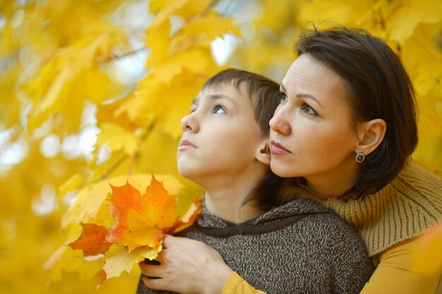 Mooie moeder met zoon in herfstpark