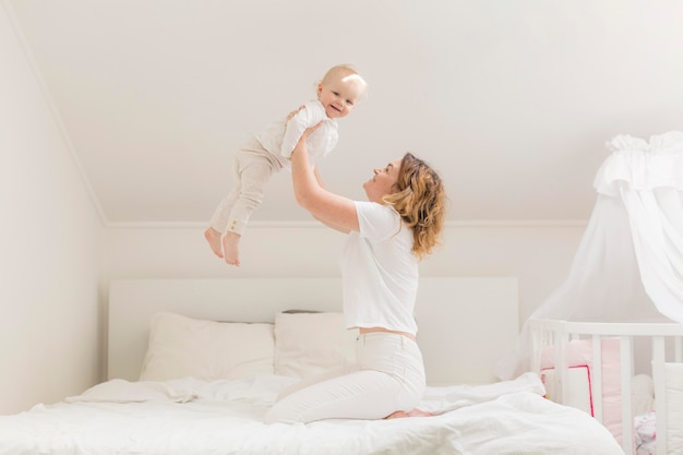 Mooie moeder spelen met schattige babymeisje