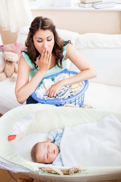 Mooie moeder verraste het zien van haar baby die vreedzaam in zijn wieg slaapt