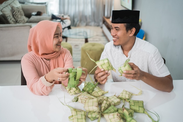 Mooie moslim paar Aziatische ketupat rijstwafel thuis maken met behulp van palmblad