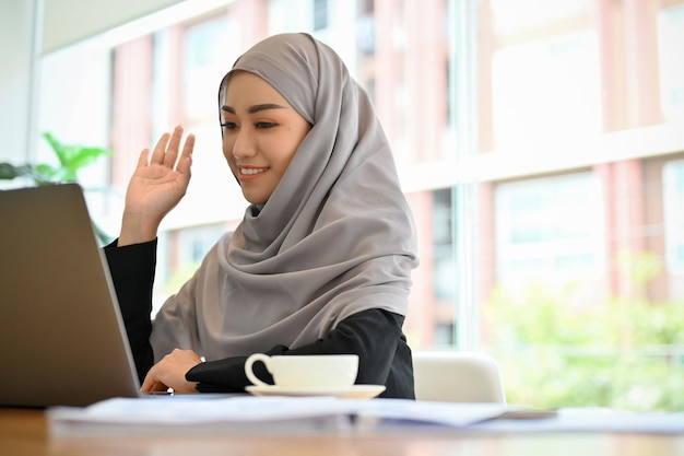 Mooie moslimvrouw of zakenvrouw die online vergadert via laptop