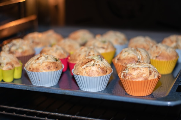 Mooie muffins in veelkleurige siliconenvormen worden in de oven gebakken