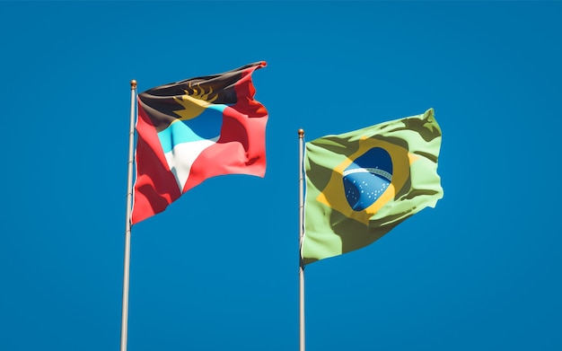 Mooie nationale vlaggen van Brazilië en Antigua en Barbuda samen op blauwe hemel