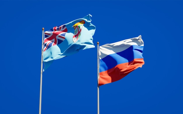 Mooie nationale vlaggen van Fiji en Rusland samen op blauwe hemel. 3D-illustraties