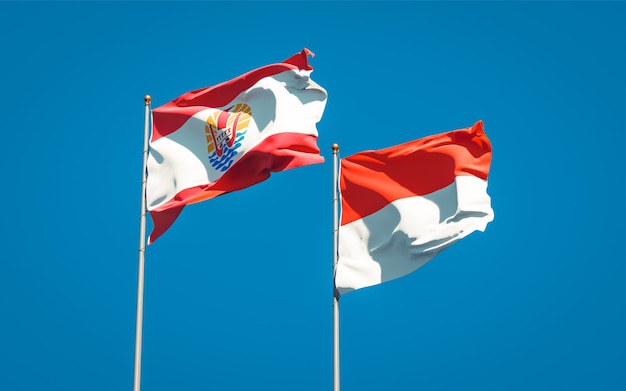 Mooie nationale vlaggen van Frans-Polynesië en Indonesië samen op blauwe hemel