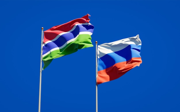 Mooie nationale vlaggen van gambia en rusland samen op blauwe hemel. 3d-illustraties