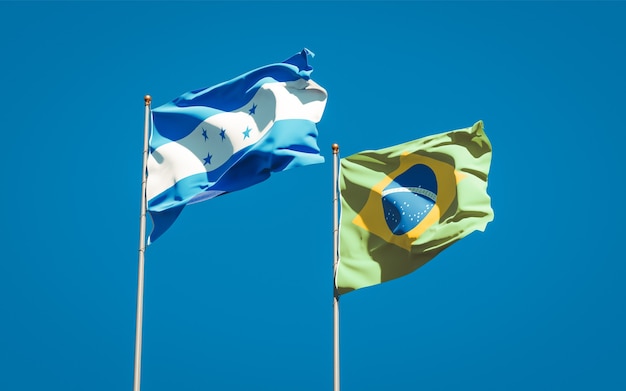 Mooie nationale vlaggen van Honduras en Brazilië samen op blauwe hemel