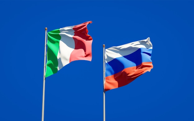 Mooie nationale vlaggen van italië en rusland samen op blauwe hemel. 3d-illustraties