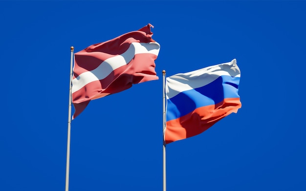 Mooie nationale vlaggen van Letland en Rusland samen op blauwe hemel. 3D-illustraties