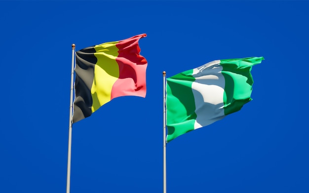 Mooie nationale vlaggen van Nigeria en België samen op blauwe hemel