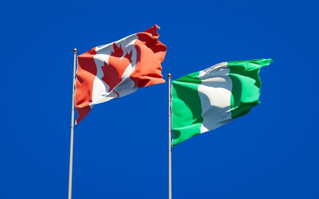 Mooie nationale vlaggen van Nigeria en Canada samen op blauwe hemel