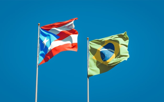 Mooie nationale vlaggen van Puerto Rico en Brazilië samen op blauwe hemel