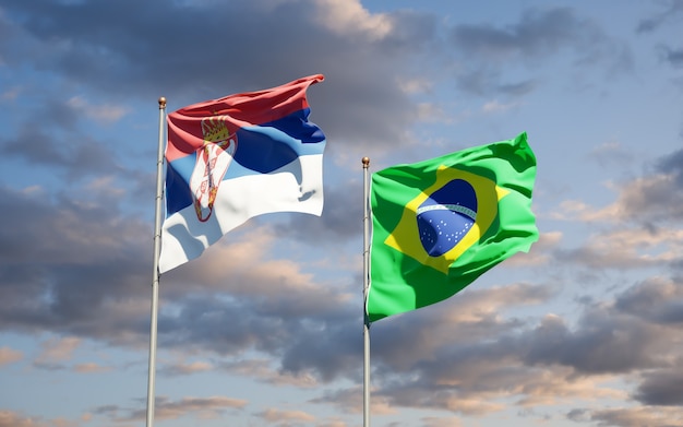 Mooie nationale vlaggen van Servië en Brazilië samen op blauwe hemel