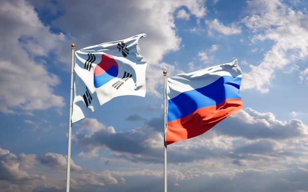 Mooie nationale vlaggen van Zuid-Korea en Rusland samen op blauwe hemel. 3D-illustraties