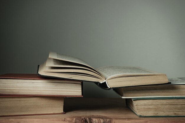 Mooie open boeken op een oude rode houten tafel en witte muur achtergrond