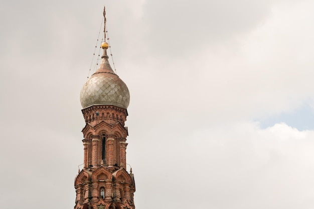 Mooie orthodoxe kerk van rode bakstenen met een koepel en kruisen tegen de blauwe lucht