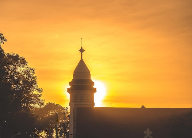 Mooie oude kerk van de stad Vung Tau met groene boom Katholiek tempeldorp Vung Tau Vietnam Foto van lentelandschap met zonsondergang