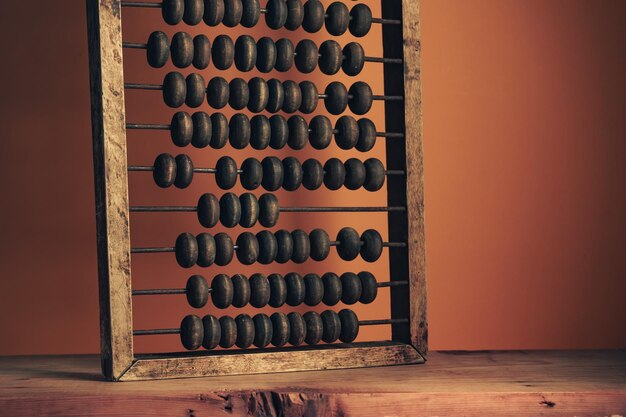 Foto mooie oude vintage houten abacus op een rode houten tafel oranje muur achtergrond