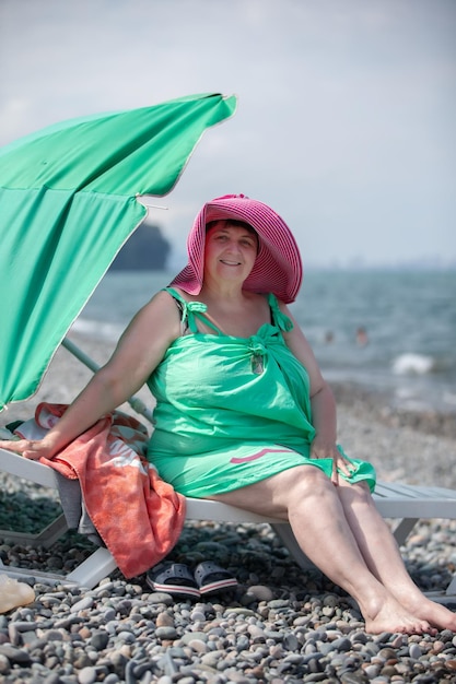 Mooie oudere vrouw ontspant zich op het strand gepensioneerd in het resort