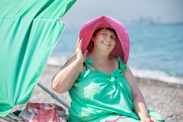 Mooie oudere vrouw ontspant zich op het strand gepensioneerd in het resort