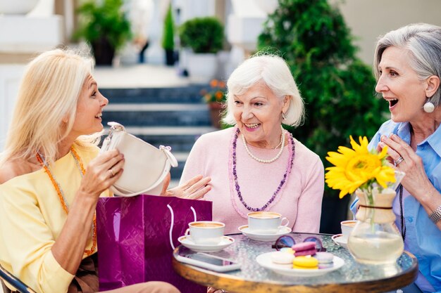 Mooie oudere vrouwen die zich aan de bar hechten