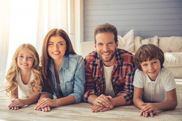 Mooie ouders en hun kinderen kijken naar de camera