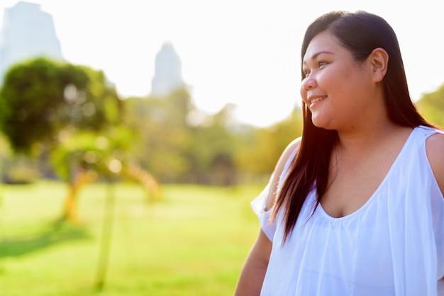 Mooie overgewicht Aziatische vrouw ontspannen in het park