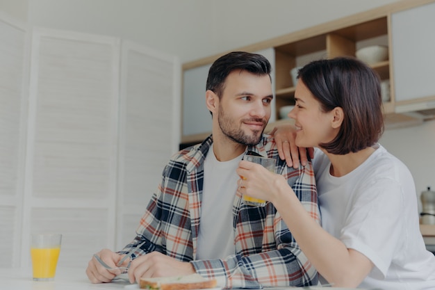 Mooie paar kijken elkaar met liefde aan, vrouw houdt glas sap