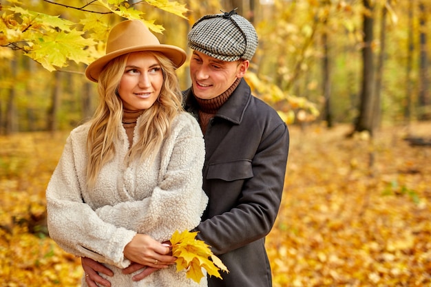 Mooie paar poseren in herfst bos, liefhebbers wandelen in het park