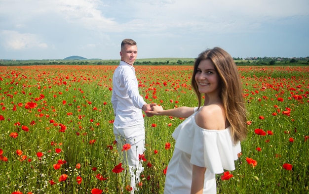 Mooie paar verliefd man en vrouw in papaver bloem veld zomervakantie gelukkige familie onder rode bloemen lente natuur schoonheid liefde en romantiek romantische relatie