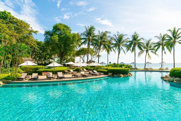 Mooie parasol en stoel rond zwembad in hotel en resort, vakantieconcept