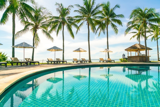 Mooie parasol en stoel rond zwembad in hotel en resort