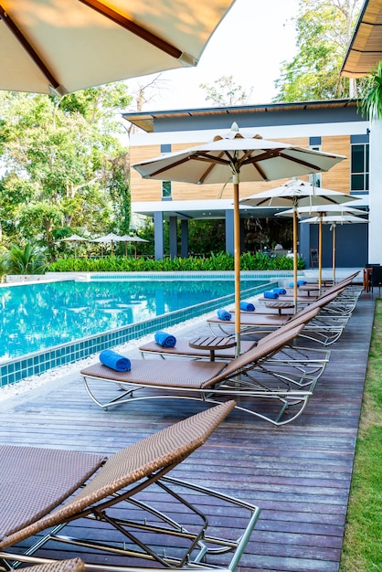 Mooie parasol en stoel rond zwembad in hotel en resort