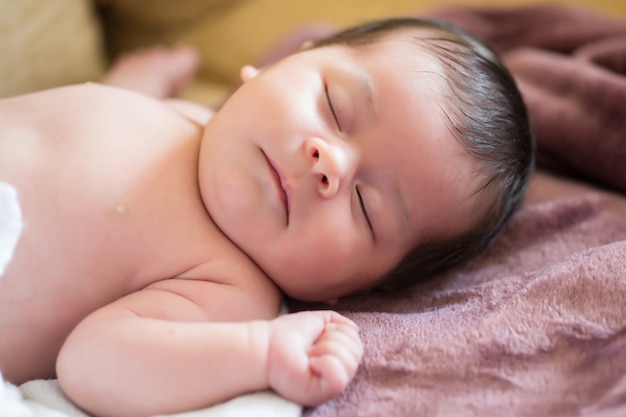 mooie pasgeboren baby in slaap op een paarse deken