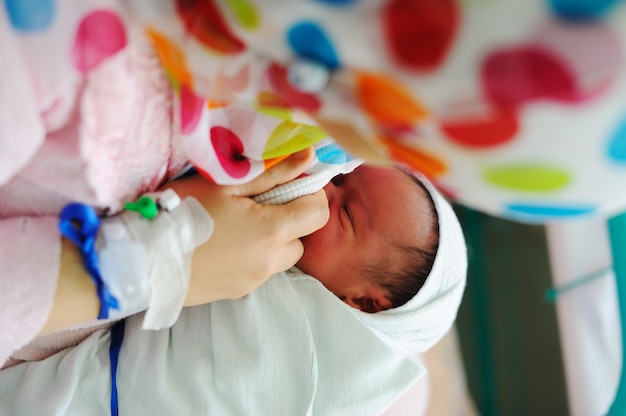 Foto mooie pasgeboren baby in zijn moeders handen.