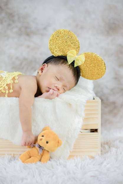 Mooie pasgeboren baby slapen in een houten kist hand met teddybeer.